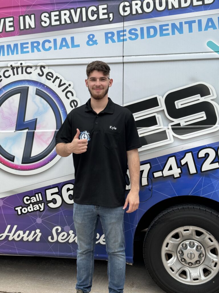 Ochoa Electric Services official van with contact details and "45-hour service" wording on it, with man in black tshirt and jeans standing beside the van
